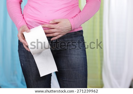 Woman with tummy ache and toilet paper middle aged