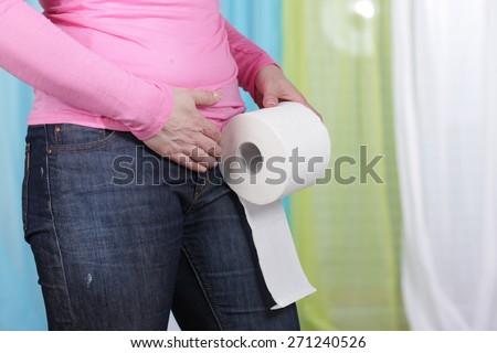 Woman with tummy ache and toilet paper middle aged