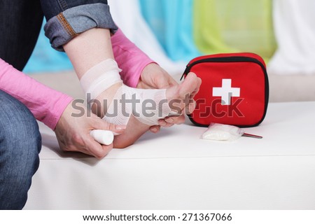 Woman taping her foot with bandage