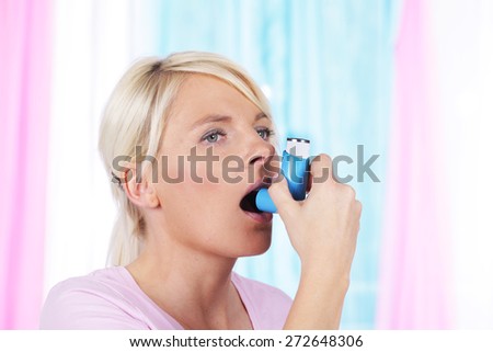 Woman with asthma spray breathing