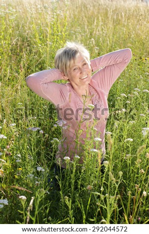Happy senior woman active in nature in summer