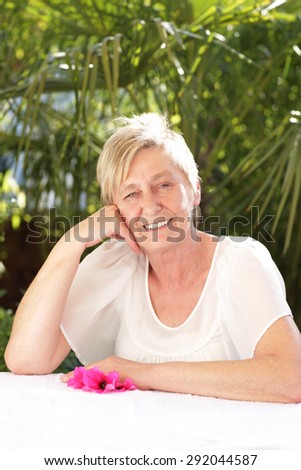 Happy senior woman relaxes in summer outdoor smiling