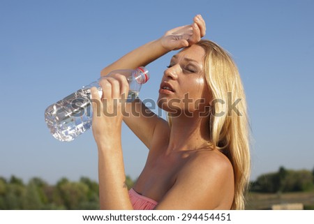 Young woman drinking water in hot summer outdoor