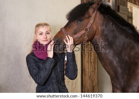 Girl holds the head of her brown pony (New-Forest-Pony)