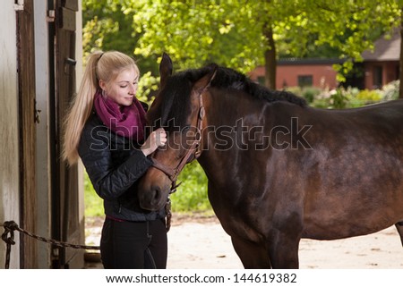 Girl strokes a brown pony (New-Forest-Pony)