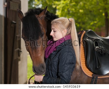 Girl is looking to her brown horse (New-Forest-Pony)