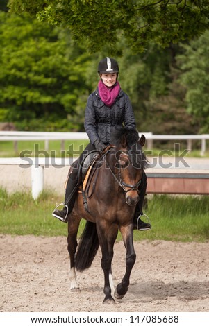 Girl rides her brown horse (New-Forest-Pony)