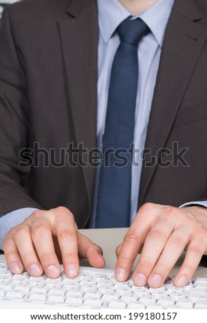 Businessman in suit is typing at the computer keyboard.
