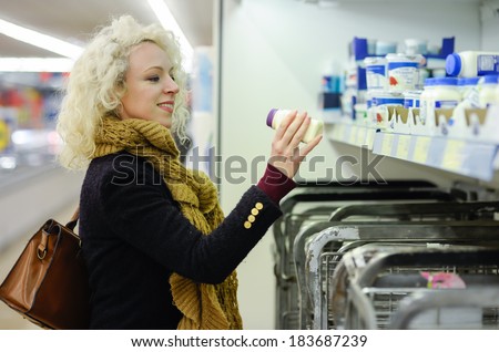 woman checking out of date label on dairy product
