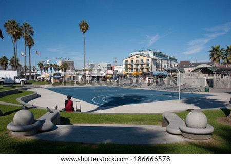 VENICE, UNITED STATES - OCTOBER 15, 2012: Man sitting by empty basketball court on Venice beach.