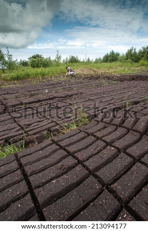 County Kerry, Ireland - May 31 2014: Workers cultivating peat bog blocks in a field outside the town of Listowel in County Kerry.