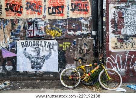 NEW YORK - SEPT 8  2012: Bicycle parked in front of Flyposting and graffiti covered wall in west Williamsburg, Brooklyn. Williamsburg has become known as an arts and culture mecca in New York city.
