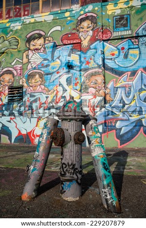 NEW YORK - OCTOBER 1ST 2012: old fire hydrant in front of Graffiti covered wall of the now gone 5Pointz graffiti mecca in Queens.
