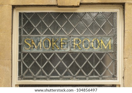 Old gold smoke room sign in an old leaded glass window in an English pub