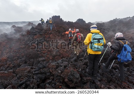 KAMCHATKA, RUSSIA - JULY 27, 2013: Group of tourists hiking on the lava field eruption Tolbachik Volcano on Kamchatka Peninsula. Russia, Far East.