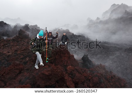 KAMCHATKA, RUSSIA - JULY 27, 2013: Group of tourists hiking on the lava field eruption active Tolbachik Volcano on Kamchatka Peninsula. Russia, Far East.