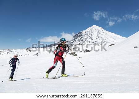 AVACHA VOLCANO, KAMCHATKA, RUSSIA - APRIL 26, 2014: Ski mountaineers climbs on skis on background volcano. Individual race ski mountaineering Asian, ISMF, Russian and Kamchatka Championship.
