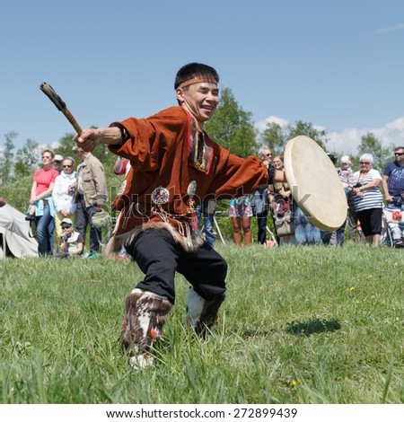 ELIZOVO, KAMCHATKA, RUSSIA - JUNE 15, 2013: Man in clothes indigenous people of Kamchatka dancing with a tambourine. Celebration of Day of the first fish - ritual celebration aborigine of Kamchatka.