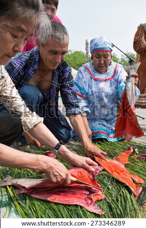 PETROPAVLOVSK-KAMCHATSKY, KAMCHATKA, RUSSIA - JULY 1, 2012: Competition for cutting (gutting) salmon (red fish) on rate. Day of the first fish - traditional celebration aborigine of Kamchatka.