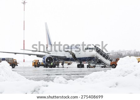 KAMCHATKA, RUSSIA - MARCH 19, 2015: Technical and service support airfield maintenance airplane Boeing-767 Transaero Airlines at airport Petropavlovsk-Kamchatsky during a snowfall and poor visibility.