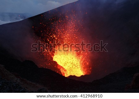Beautiful night volcanic eruption - a view of the lava lake and a lava fountain, escaping from the crater. Erupting Tolbachik Volcano (Klyuchevskaya Group of Volcanoes). Russian Far East, Kamchatka.