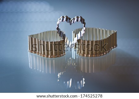 Metal rough molds heart shaped on a blue background isolated. Love in Valentine's Day.