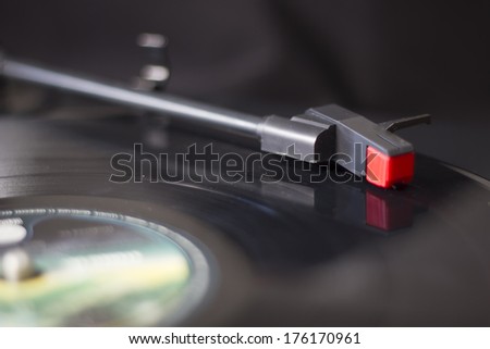 A real retro turntable arm playing on a vinyl disc. Vintage quality music.