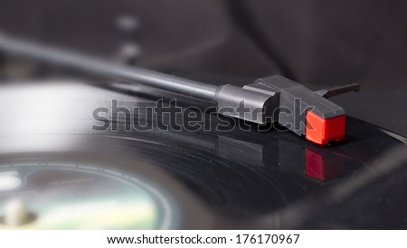 A real retro turntable arm playing on a vinyl disc. Vintage quality music.