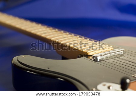A lefty electric guitar sunburn on a blue background. Left handed musical instrument for rock blues and country.