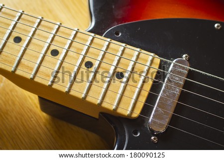 A left handed electric guitar close up shot on a wooden background.