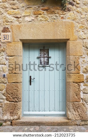 Beautiful old blue metal door on an old rock and stone medieval house in a perfect condition.