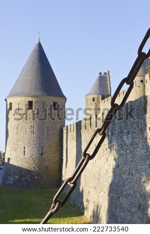 Medieval famous landmark in France. Old tower and stone wall on a metal chain.