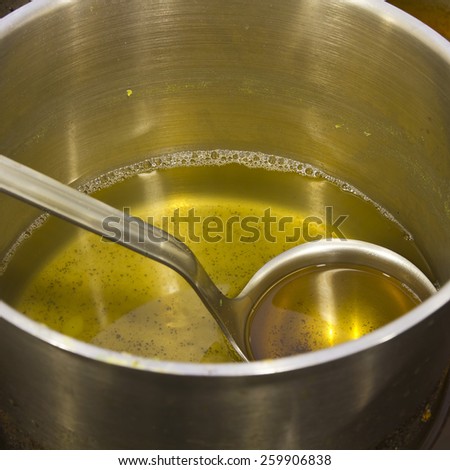 Cooking oil waste on a pot with a spoon on a close up still.