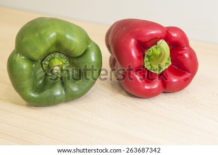 Fresh peppers isolated on a wood domestic kitchen background. Diverse spice vegetables, red and green.