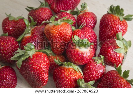 Many bright red strawberries on a fruity background.