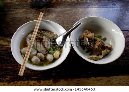 China soup with meatball ,vegetable in white bowl ,chopsticks and spoon in the bowl.Top view shot.