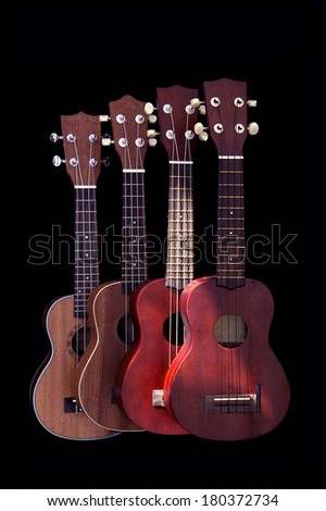 Four Acoustic Guitar  stand on Black background. Lighting place upon on Guitars.