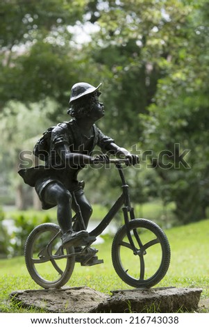 BANGKOK,THAILAND-8 SEPTEMBER 2014 : Boy drive bicycle statue in Jatujak Train Public Park,famous and celebrated public park in Bangkok.