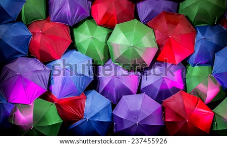 Umbrella with party colored arrange on background with reflection of lighting.