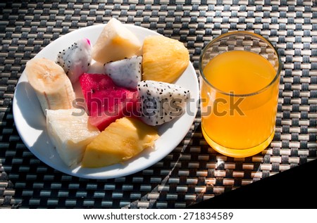 Orange juice and fruit set on table with sunshine light at early morning.