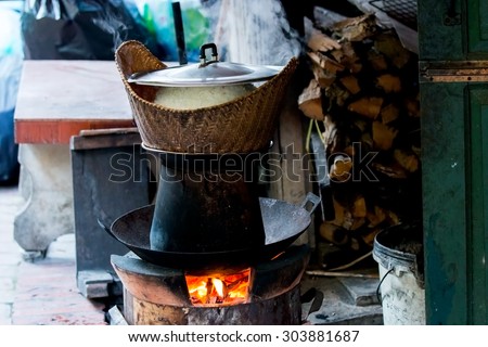 Cook sticky rice with firewood and wood stove in laos kitchen. Sticky rice is tradition food of laos people.