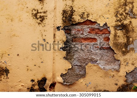 The yellow wall peel off, see through brick wall and cement inside.