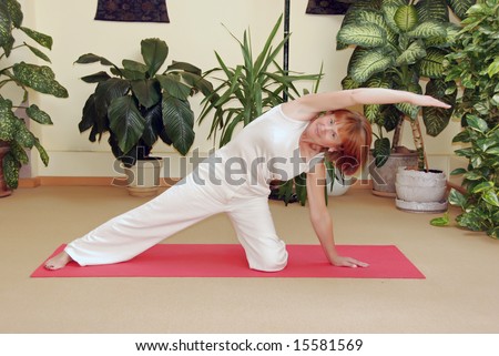 Senior lady practicing yoga in yoga school