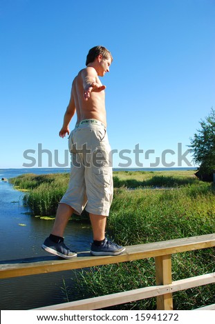 Young man balance on a wooden bridge