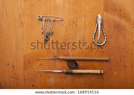 crochet tools, needles, safety pin and tailor tools  craft concept on wooden texture
