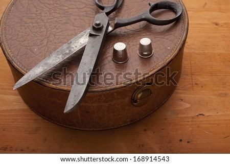dressmaker shears on leather box craft concept on wooden texture