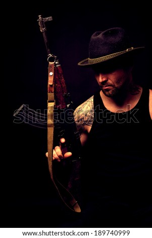 portrait of gangster with hat and gun in the darkness.