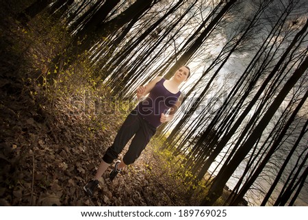 Woman running in wooded forest area, training and exercising
