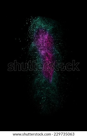 Stop motion of pink nad green dust explosion isolated on black background