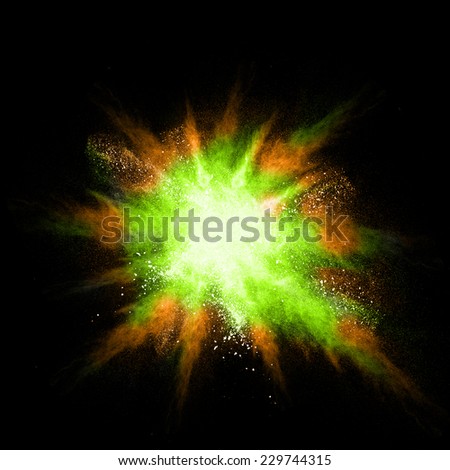 Stop motion of green and orange dust explosion isolated on black background